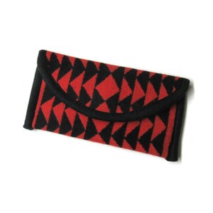 May include: A red and black geometric patterned wallet with a black trim.