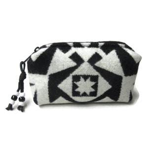 May include: Black and white geometric patterned zippered pouch with a black and white beaded tassel.