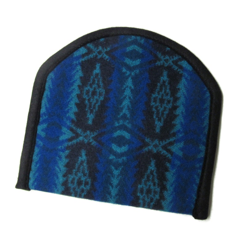 May include: A blue and black patterned eye mask with a black trim. The eye mask is made of a soft, fuzzy material.