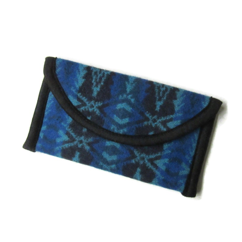 May include: A blue and black patterned wallet with a black trim. The wallet is made of a soft, textured fabric.