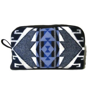 May include: A rectangular, zippered pouch with a geometric pattern in shades of blue, white, and black. The design features diamond and triangle shapes. The pouch has a black zipper and a small black loop on one side.