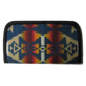May include: Rectangular case with a Southwestern-inspired design. The case features a geometric pattern in shades of blue, beige, red, orange, and white, with a black border. The design is reminiscent of traditional woven textiles.