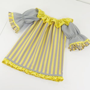 May include: A yellow and gray striped dress with a ruffled neckline and sleeves. The dress has a yellow and white patterned trim around the neckline, sleeves, and hem.