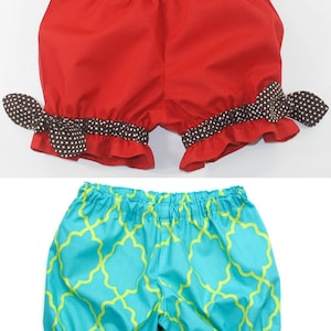 May include: Two pairs of toddler-sized bloomers. The top pair is red with brown and white polka dot trim. The bottom pair is turquoise with a green geometric pattern and red, white, and brown trim.