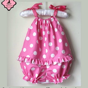 May include: Pink baby romper with white polka dots and a ruffle trim. The romper has short legs and a center ruffle.