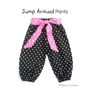 May include: Black and white polka dot pants with a pink and red patterned fabric belt. The pants have a gathered elastic waistband and are labeled "Jump Around Pants".