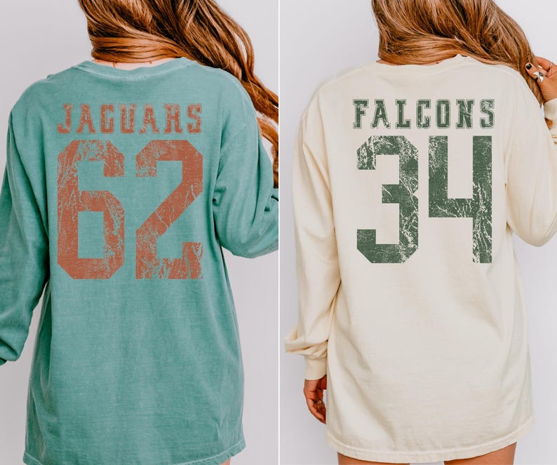 May include: Two long-sleeved shirts. One is teal with "JAGUARS" and the number "62" in distressed orange lettering. The other is cream-colored with "FALCONS" and the number "34" in distressed green lettering.