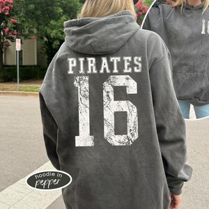 May include: A gray hoodie with the word "PIRATES" and the number "16" printed on the back in white. The hoodie has a drawstring hood and a front pocket. The image also shows a smaller image of the same hoodie.