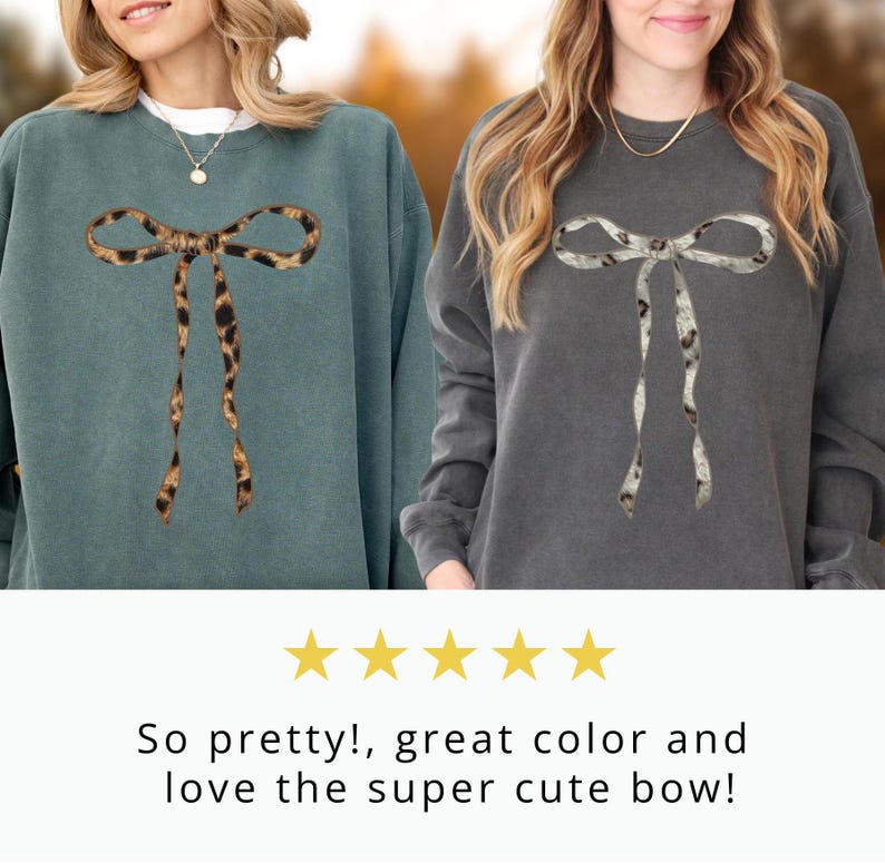May include: Two women wearing sweatshirts with a large bow design. The bow is made of a leopard print fabric on one sweatshirt and a white and gray print on the other.