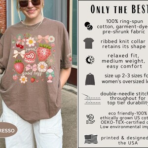 Op de afbeelding: Espresso-kleurig T-shirt met een aardbei- en bloemenafbeelding. Het shirt heeft de tekst "sweet goodness" en is gemaakt van ringgesponnen katoen. Het ontwerp is gedrukt en ontworpen in de VS.