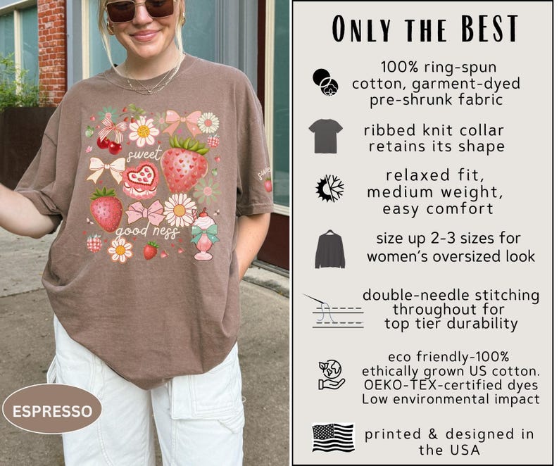 Op de afbeelding: Espresso-kleurig T-shirt met een aardbei- en bloemenafbeelding. Het shirt heeft de tekst "sweet goodness" en is gemaakt van ringgesponnen katoen. Het ontwerp is gedrukt en ontworpen in de VS.