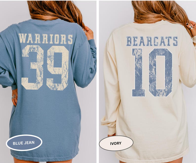 May include: Two long-sleeved shirts with distressed text and numbers on the back. One is blue jean with "WARRIORS" and the number "39". The other is ivory with "BEARCATS" and the number "10". Both shirts have a vintage, worn look.