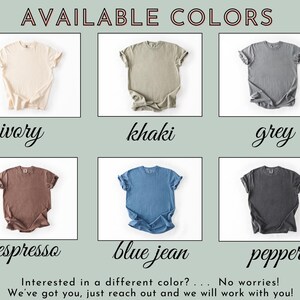 May include: A display of t-shirts in various colors, including ivory, khaki, grey, espresso, blue jean, and pepper. The text "AVAILABLE COLORS" is at the top. The text "Interested in a different color? ... No worries! We've got you, just reach out and we will work with you!" is at the bottom.