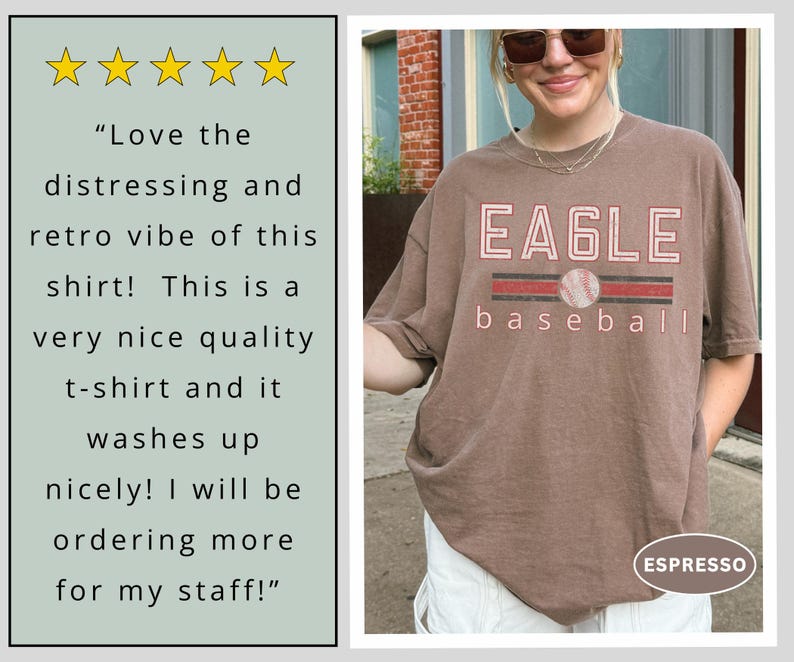 May include: Espresso-colored t-shirt with the word "EAGLE" in a distressed, retro style, with a baseball graphic. The word "baseball" is below the graphic. The shirt has a vintage look.