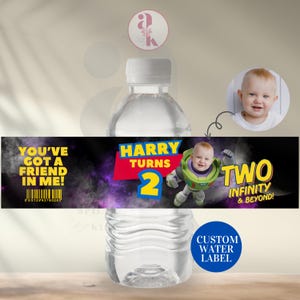 May include: A water bottle with a custom label for a second birthday. The label features the text "Harry Turns 2" with a cartoon image of a baby dressed as Buzz Lightyear. The label also includes the text "You've Got a Friend in Me!" and "Two Infinity & Beyond!"