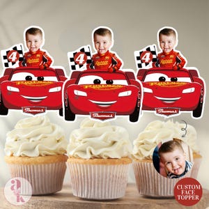 May include: Cupcakes with custom face toppers featuring a child in a red race car design. The toppers include the number 4, a checkered flag, and the name "Thomas". The cupcakes have white frosting.