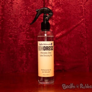 May include: A clear bottle with a black spray nozzle. The bottle is labeled "BoohiDress Affordably Shiny Latex Dressing Aid".