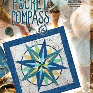May include: A quilt with a compass design, featuring shades of blue, green, and yellow. The quilt has a dark blue border and a white background with a compass rose pattern. The words "POCKET COMPASS" are at the top, with "Timeless Treasures" and "Quiltworx.com" also visible.