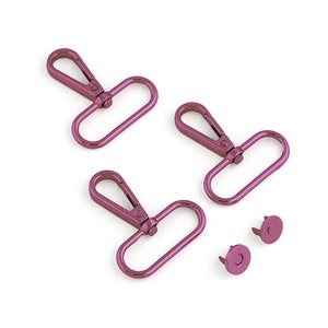 May include: Three pink metal swivel clasps and two pink metal snap fasteners.