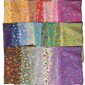 May include: A collection of rectangular fabric swatches arranged in a grid, each featuring a repeating pattern of multicoloured concentric circles. The fabric pieces display a wide spectrum of colours including yellow, orange, red, pink, blue, green, brown, black, grey, and purple.