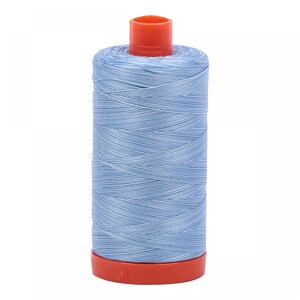 May include: A spool of light blue thread with an orange plastic bobbin.