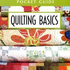 May include: A book titled "Pocket Guide Quilting Basics" with a stack of colorful patchwork quilts in the background.