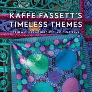 May include: A book cover featuring a colorful quilt with a circular pattern in shades of blue, green, and purple. The title "Kaffee Fassett's Timeless Themes" is displayed in bold white letters on a dark blue background. The subtitle "23 New Quilts Inspired by Classic Patterns" is displayed in white letters on a dark blue background. The author's name "Kaffee Fassett with Liza Prior Lucy" is displayed in white letters on a dark blue background. The photographer's name "Photographs by Debbie Patterson" is displayed in white letters on a dark blue background.