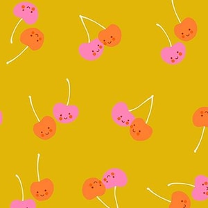 May include: Mustard yellow fabric featuring a repeating pattern of smiling cherries in pink and orange. The cherries have white stems and are scattered across the fabric. The text "RUBY STAR SOCIETY" is printed at the bottom.