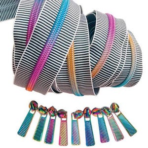 May include: A roll of black and white striped zipper tape with colorful zipper teeth in shades of pink, orange, blue, and teal. Below are several iridescent zipper pulls.
