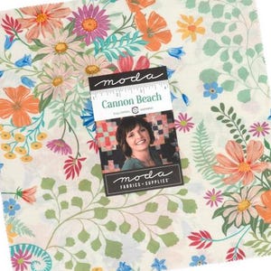May include: A square fabric piece with a floral pattern in shades of orange, pink, blue, and green. The fabric has a cream background and a tag that reads "Cannon Beach" by Moda Fabrics + Supplies.