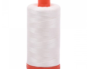 May include: A spool of white sewing thread wound onto a cylindrical plastic core. The spool features a bright orange plastic cap at the top and a matching orange base with the embossed text AURIFIL and BREV visible along the bottom edge.