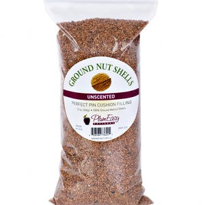 May include: A clear plastic bag filled with ground walnut shells. The bag has a label that reads "Ground Nut Shells Unscented Perfect Pin Cushion Filling 12 oz (340g) 100% Ground Walnut Shells PlumEasy Patterns Made in USA PEP-301".