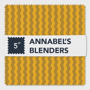 May include: A fabric swatch with a repeating wavy pattern in shades of gold and brown. A white label displays the text "ANNABEL'S BLENDERS" and a 5-inch square. The edges of the fabric are scalloped.