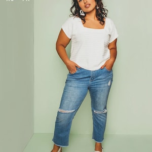 May include: A woman wearing a white square neck top and blue jeans with distressed knees. The top is paired with white shoes. Text on the image reads "FRIDAY pattern co." and "the Square Neck Top."