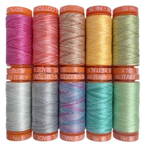 May include: Ten spools of Aurifil cotton thread arranged in two rows of five. The spools feature orange caps with text including 100% COTTON, MADE IN ITALY, and Ne 50 or Ne 60. The thread colors include pink, coral, tan, yellow, lime, silver, gray, variegated blue-pink, teal, and light green.