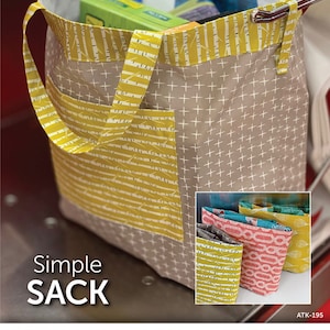 May include: A sewing pattern for a simple sack, featuring a gray and yellow fabric with a white cross pattern. The pattern is called "Simple Sack" and is from Atkinson Designs. The pattern number is ATK-195.