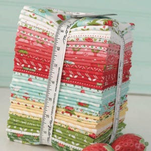 Peut inclure: Une pile de carrés de tissu pliés dans des tons de rouge, rose, jaune, vert et bleu clair, avec des motifs de fraises et de fleurs. Un ruban à mesurer blanc marqué en centimètres entoure la pile, et deux fraises en céramique sont posées à côté.