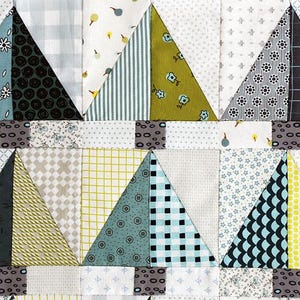 May include: A patchwork quilt with a geometric pattern of triangles in various shades of blue, green, yellow, and gray. The triangles are arranged in rows and columns, creating a visually appealing design.