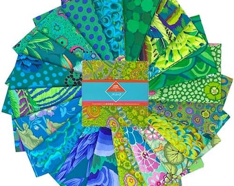 May include: A fabric charm pack featuring a variety of square cotton pieces arranged in a circular fan pattern. The textiles display diverse patterns including polka dots, floral motifs, and abstract shapes in shades of green, blue, and purple.