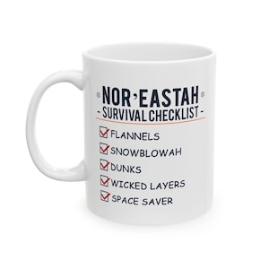 May include: White ceramic mug with a blue and white design. The mug features the text "Nor'Eastah - Survival Checklist -" with a checklist of items including "Flannels", "Snowblowah", "Dunks", "Wicked Layers", and "Space Saver".