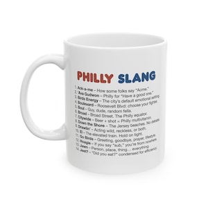 May include: White ceramic mug featuring the text "PHILLY SLANG" in red and blue. The mug lists 14 common Philadelphia slang terms and their meanings. A perfect gift for anyone from Philadelphia or a fan of the city.