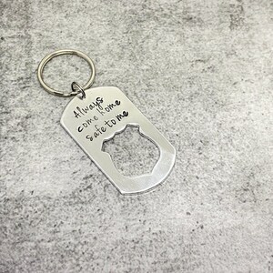 May include: Silver keychain with a police badge cutout and the inscription "Always come home safe to me".