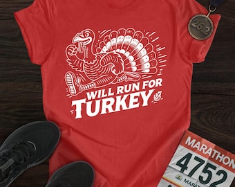 Könnte beinhalten: Rotes T-Shirt mit weißer Grafik einer laufenden Pute und dem Text "WILL RUN FOR TURKEY". Eine Marathonmedaille und Laufschuhe sind ebenfalls zu sehen.