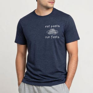 Peut inclure: T-shirt bleu marine avec l'inscription blanche "eat pasta run fasta" et un dessin de pâtes. Le t-shirt à col rond et manches courtes est idéal pour un look décontracté.