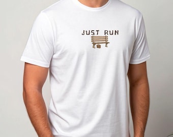 Puede incluir: Camiseta blanca con el texto "JUST RUN" sobre un gráfico de banco marrón y un pequeño maletín marrón. La camiseta tiene mangas cortas y cuello redondo.