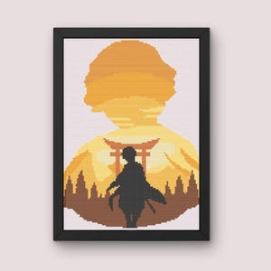 Może przedstawiać: Sztuka haftu krzyżykowego w czarnej ramie. Grafika przedstawia sylwetkę osoby przed japońską bramą Torii i tłem w kolorze zachodzącego słońca. Wzór haftu krzyżykowego wykorzystuje odcienie pomarańczowego, brązowego i czarnego.