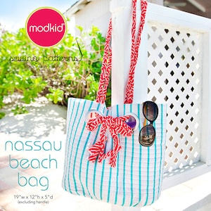 May include: A striped beach bag with red and white handles, a red bow, and sunglasses. The bag is 19 inches wide, 12 inches high, and 5 inches deep, excluding the handle. The text "Nassau beach bag" is printed on the front of the bag.