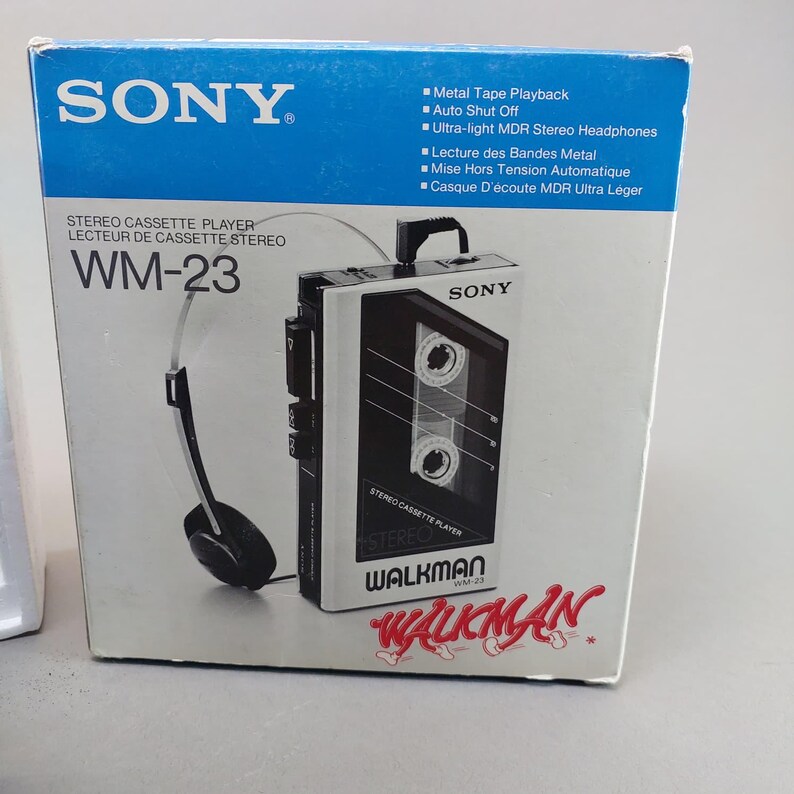 May include: A Sony Walkman WM-23 stereo cassette player in its original blue and white packaging. The box displays the device, ultra-light MDR stereo headphones, and features including metal tape playback and auto shut off in English and French.