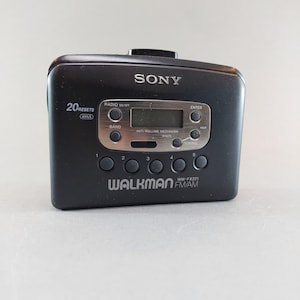 May include: Black Sony Walkman WM-FX221 FM/AM radio cassette player. Features include 20 presets, a digital display, and control buttons. The Walkman has the Sony logo and the Walkman logo.