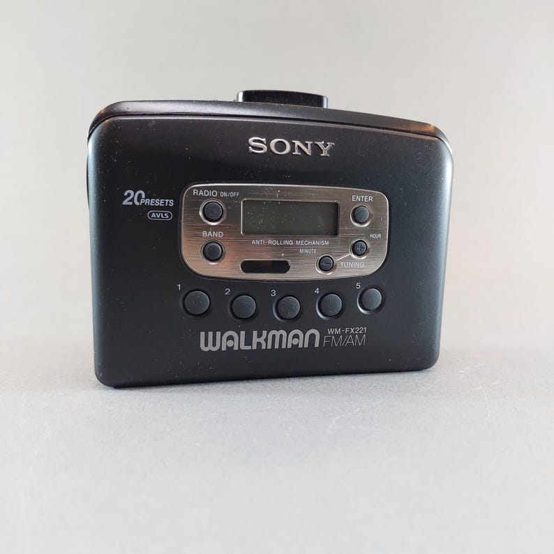 May include: Black Sony Walkman WM-FX221 FM/AM radio cassette player. Features include 20 presets, a digital display, and control buttons. The Walkman has the Sony logo and the Walkman logo.
